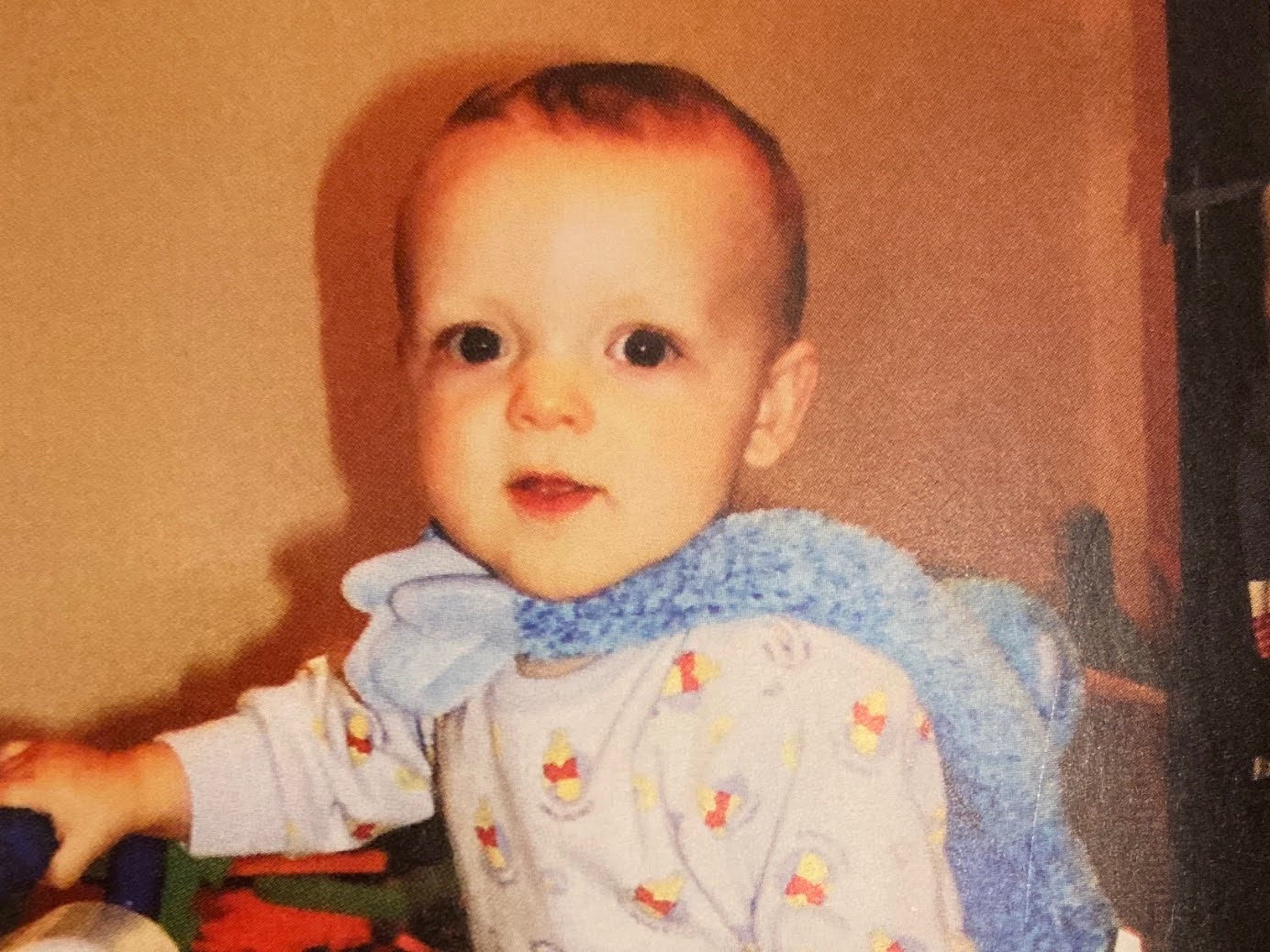 Beau as a baby in Winnie-the-Pooh pajamas with a blue scarf